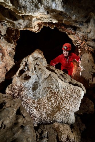 Grotte du Sud de l'Arizona (USA) - Spéléo regardant des cristaux de calcite sur un bloc(SP-20-0237)
